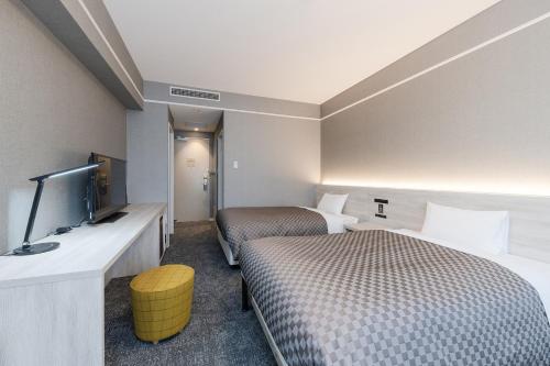 ein Hotelzimmer mit 2 Betten und einem Flachbild-TV in der Unterkunft The One Five Garden Kurashiki - Vacation STAY 40174v in Kurashiki