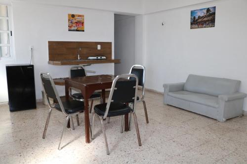 a dining room with a table and chairs and a couch at Hotel Tropical in Progreso