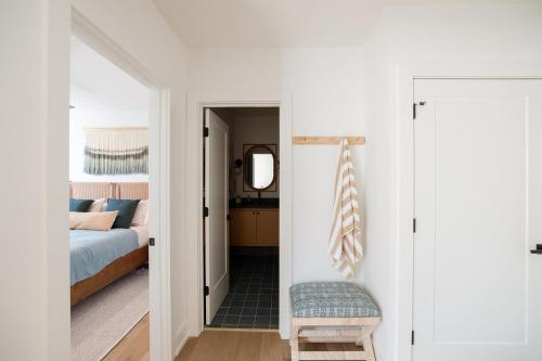 a bedroom with a bed and a room with a mirror at The Atlantic at The Tarrymore in Wrightsville Beach