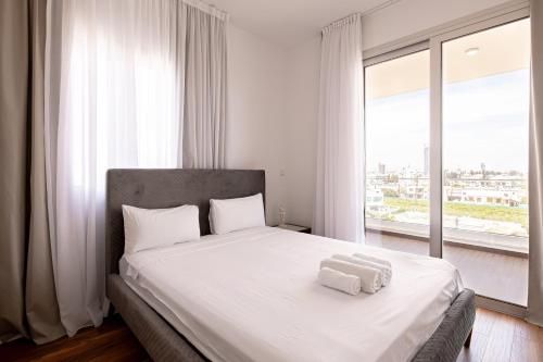ein Schlafzimmer mit einem Bett mit zwei Handtüchern darauf in der Unterkunft YAMAS Urban Living Sunny Pool Penthouse in Limassol