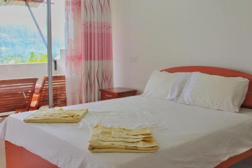 um quarto com uma cama com duas toalhas em The Dream Inn em Ella
