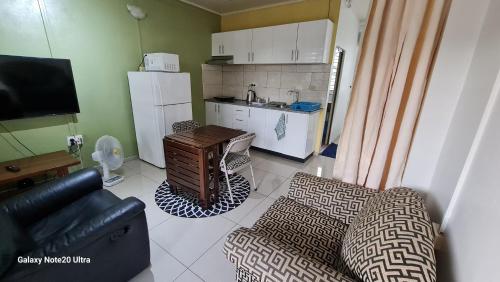 a living room with a couch and a kitchen at Cosy 2 bedroom unit with pool,Wifi in Suva