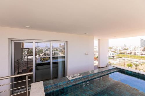 ein Haus mit einem Pool und einem Balkon in der Unterkunft YAMAS Urban Living Sunny Pool Penthouse in Limassol