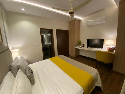 a hotel room with a bed and a television at Rosewood Lahore in Lahore