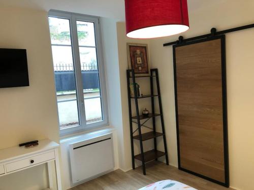 Zimmer mit einem Schlafzimmer mit einer Tür und einem Fenster in der Unterkunft Charmant appartement centre ville avec cour in Chalon-sur-Saône