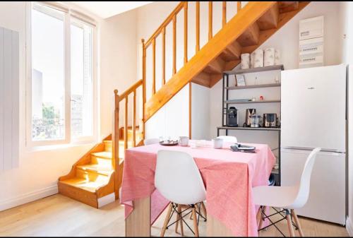 uma sala de jantar com uma mesa e cadeiras brancas em Cocon De confort proche de Paris em Créteil