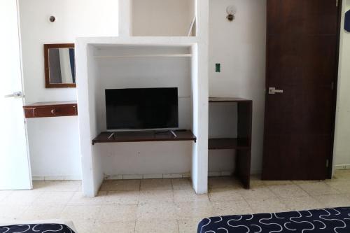 a living room with a tv in a room at Hotel Tropical in Progreso