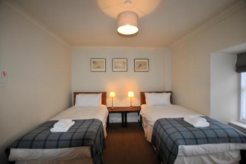 2 camas en una habitación con 2 lámparas en una mesa en St Annes Crail- grand family home en Crail