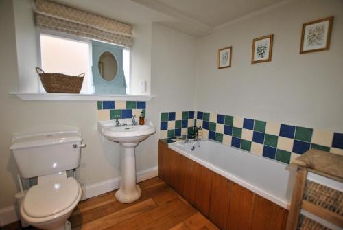 a bathroom with a sink and a toilet and a bath tub at St Annes Crail- grand family home in Crail