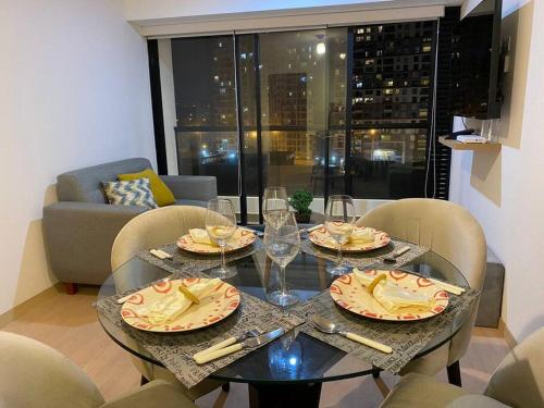 a dining table with plates and wine glasses on it at Apartamento en Barranco in Lima