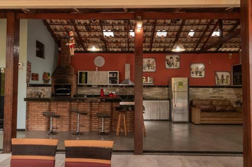 Il comprend une cuisine dotée de murs rouges et une cuisine équipée d'un réfrigérateur. dans l'établissement Vivenda Mirante Do Sol, à Contagem