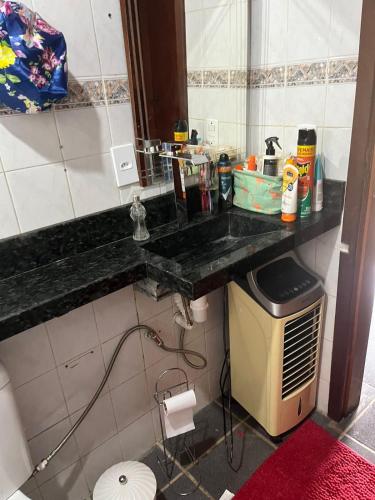 uma casa de banho com um balcão preto e um lavatório em Chalé aconchegante em Itu