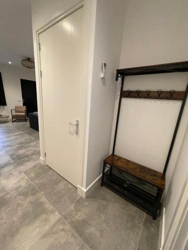a room with a white door and a wooden bench at B en B Stipdonk in Lierop