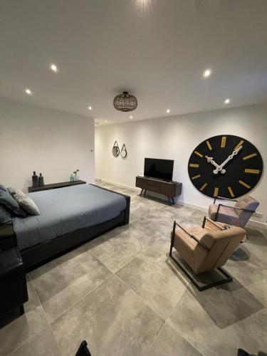 a bedroom with a large clock and a bed and a chair at B en B Stipdonk in Lierop
