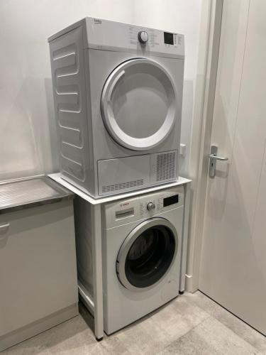 a washing machine and a dryer in a room at B en B Stipdonk in Lierop