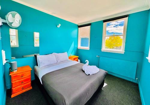 Dormitorio azul con cama y pared azul en Crashpalace Backpackers, en Rotorua