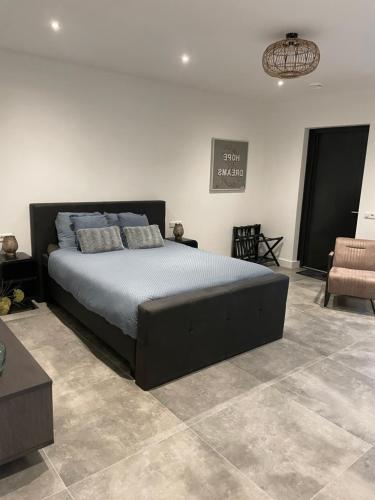 a bedroom with a large bed and a chair at B en B Stipdonk in Lierop