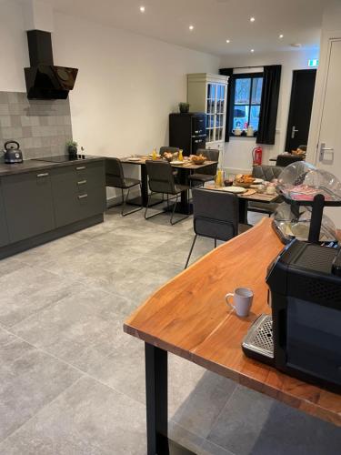 a kitchen with tables and chairs in a room at B en B Stipdonk in Lierop
