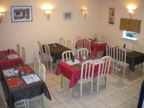 ニッサン・レ・アンサリューヌにあるL 'Acropoleの赤いテーブルクロスのテーブルと椅子が備わるレストラン