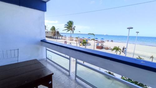 einen Balkon mit einer Bank und Strandblick in der Unterkunft Hotel Tropical in Progreso