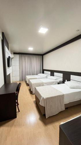a room with four beds in a room at Regente Hotel in Pato Branco