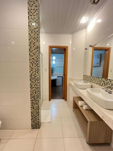 a bathroom with two sinks and a mirror at Regente Hotel in Pato Branco