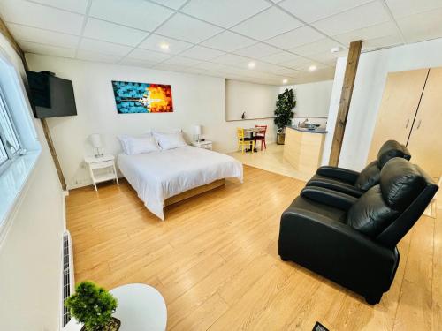 a living room with a bed and a couch at L'APPÂT buvette et couchette de Sainte-Luce - Appartements de vacances modernes, calmes et ressourçant sur le fleuve in Sainte-Luce-sur-Mer