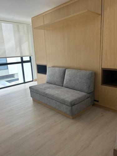 um sofá sentado numa sala de estar num quarto em Apartamento en Usaquen em Bogotá