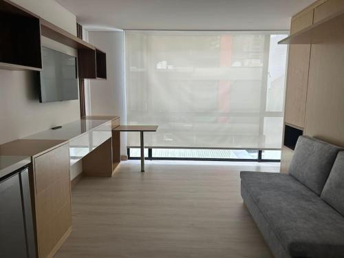 uma cozinha com um sofá e uma mesa num quarto em Apartamento en Usaquen em Bogotá