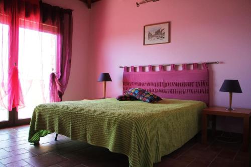 1 dormitorio con 1 cama con paredes de color rosa y verde en St.Nikola house, en Astris