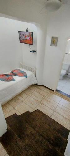 a bedroom with a bed and a rug on the floor at Hotel Casa Branca in Guarujá