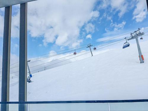 a ski lift with people on it in the snow at Atrium New Gudauri by Gudauri Travel in Gudauri