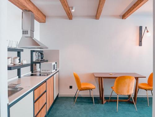 a kitchen with orange chairs and a wooden table at Atrium New Gudauri by Gudauri Travel in Gudauri