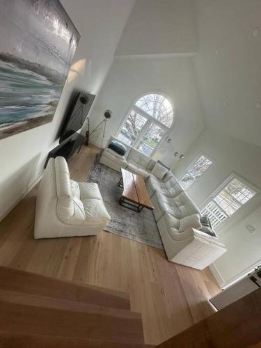 sala de estar con 2 sillas blancas y TV en Modern Luxury Retreat Spacious Serene Oasis en Silver Spring