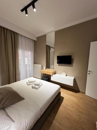 拉米亞的住宿－La Maison Luxury，卧室配有白色的床和书桌