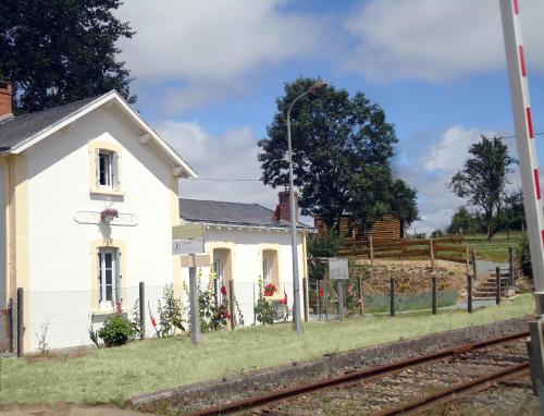 a small white house next to a train tracks at Bienvenue à la halte de Sigournais ancienne Gare in Sigournais