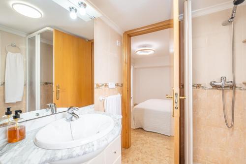 uma casa de banho com um lavatório e um chuveiro em Apartamento Currus Miramar Playa em Benidorm