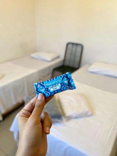 a person holding up a blue wrapper in a room at Hotel Mendes Azevedo in Goiânia