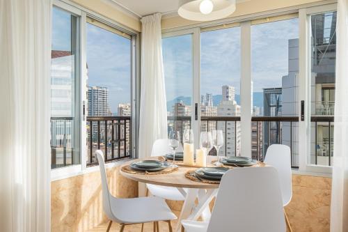 a dining room with a table and chairs and large windows at Apartamento Currus Miramar Playa in Benidorm