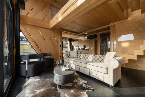 a living room with a white couch and a table at Chaletovo Mountain Residences in Zakopane