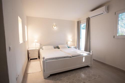 a bedroom with a white bed and a window at Boutique Hotel CASA CARACOL - Apartments in Strandnähe, Salzwasserpool, Fotovoltaik, Adults Only in San Jose