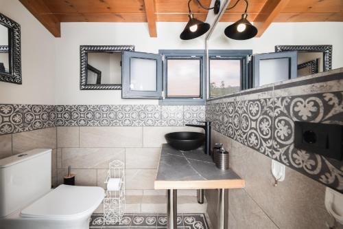 a bathroom with a toilet and a sink at Athenea Villas, Private Pools & Gardens in Keri