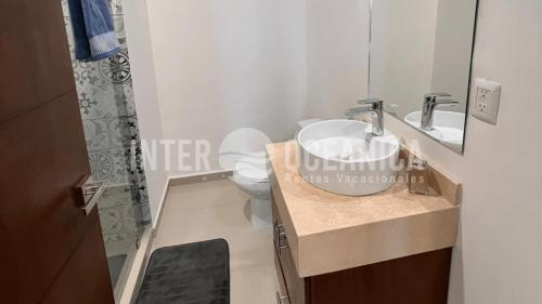 a bathroom with a sink and a toilet and a mirror at Alberca con la mejor vista a la Marina Mazatlán in Mazatlán