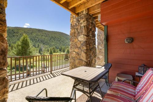 a patio with a wooden table and chairs on a porch at 5949 Hidden River Lodge Condo in Keystone
