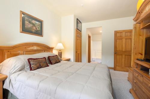a bedroom with a large white bed and a television at 5949 Hidden River Lodge Condo in Keystone