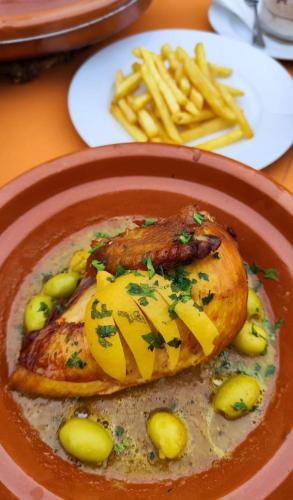 a plate of food with meat and french fries at Hôtel Restaurant BOUGAFER in Oulad Akkou