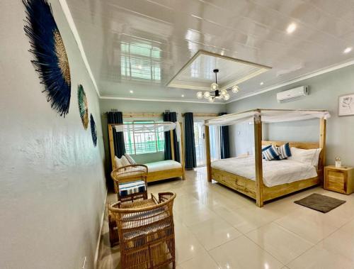 1 dormitorio con 1 cama con dosel y sillas en Ndau Lodge en Nkhata Bay