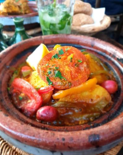 a plate of food with meat and fruit on a table at Hôtel Restaurant BOUGAFER in Oulad Akkou
