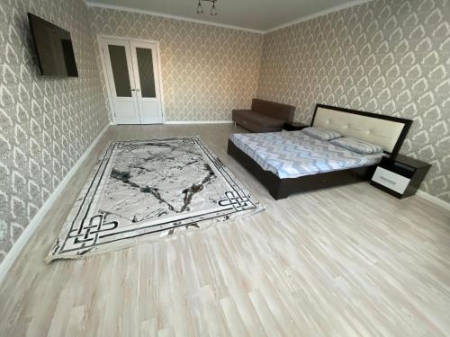 阿克托比的住宿－Уютная кв в ЖК Нектар мкр Батыс-2，一间卧室配有一张床和地毯
