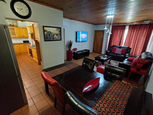 a living room with a table and chairs and a clock at Sabie House -3 bedroom house in Kempton Park